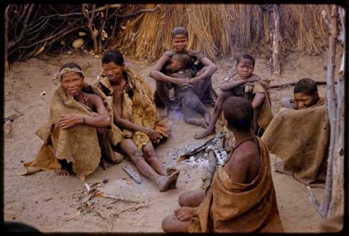 Group of people sitting by a fire