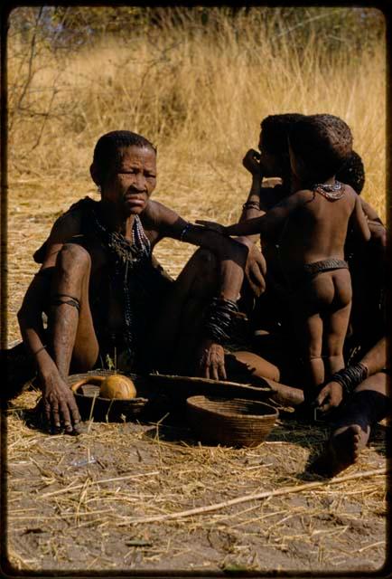 Woman sitting, with a child standing next to her