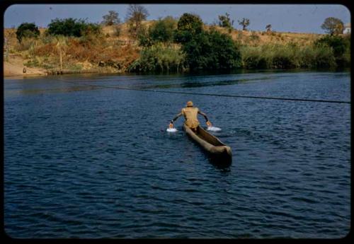 Man paddling a mokoro (makoro) with his hands along the Okavango River