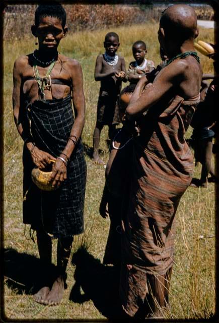 Two women standing, with two children behind them, kept hostage by Keremendi in the Oshimporo omuramba