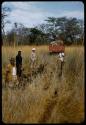 Heinrich Neumann, Philip Hameva, Nicolaas Jacobus van Warmelo and Kurt Ahrens next to ruts left by expedition truck crossing the Oshimporo omuramba