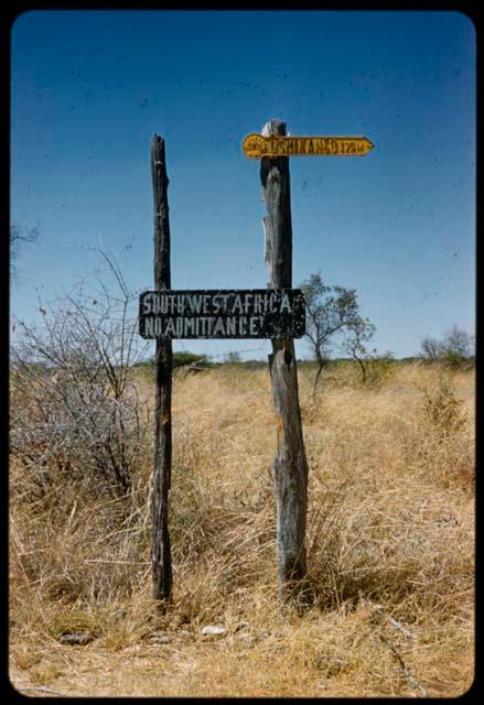 Signs at the border between South West Africa and Angola: "Ushikango 175m" and "South West Africa, No Admittance"