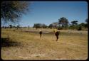 Two women carrying fish traps