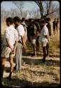 Men standing, waiting to be paid by Mr. Kruger for work on a fire break, view from behind