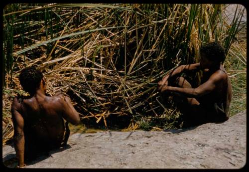 ≠Toma sitting with an unidentified man next to the Gautscha waterhole