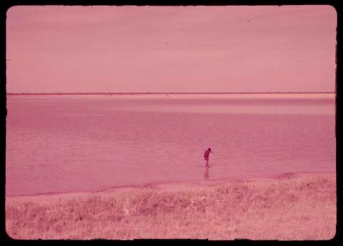 Woman bathing in a water-filled pan, distant view