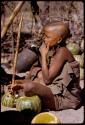 Two women sitting, eating tsama melons