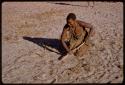 Woman demonstrating cultivating with a digging stick