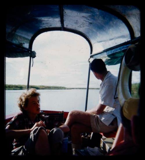 Elizabeth Marshall Thomas and another expedition member riding in a barge on the Okavango River