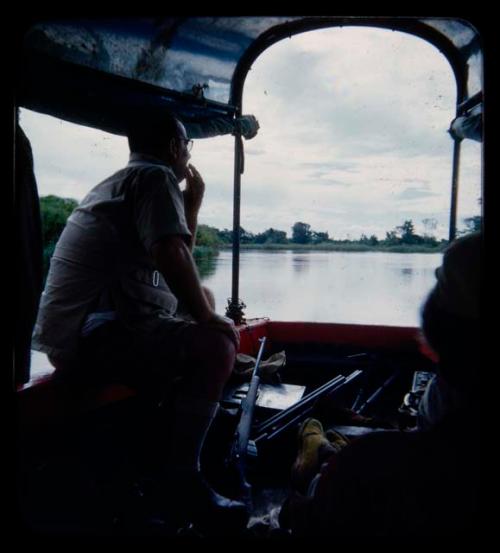 C.J. Mathias sitting on a rail of a barge on the Okavango River