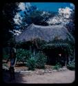 Hut decorated with flowers and a person walking in the foreground