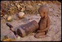 N!whakwe holding a wooden mortar