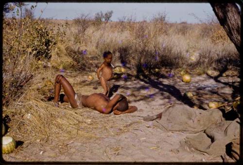 Gai sleeping, N!whakwe walking by