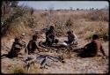 Oukwane and Gai sitting with Kernel Ledimo, /Gishay, and Lorna Marshall with a notebook