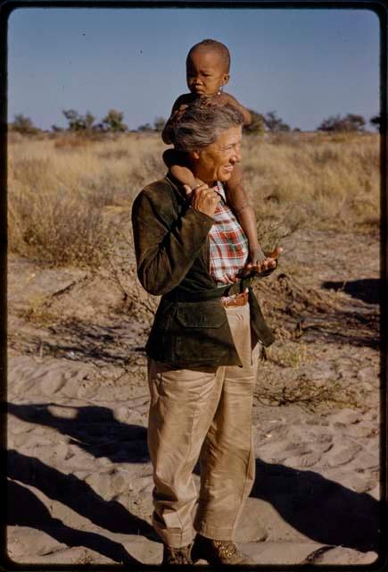 Lorna Marshall standing with N!whakwe on her shoulders