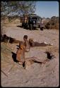 Gai, Oukwane, Kernel Ledimo, and another person lying on the ground, expedition truck in the background