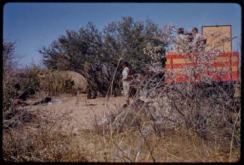 Lorna Marshall standing, Elizabeth Marshall Thomas and John Marshall sitting in expedition truck