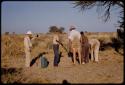 Expedition members standing around John Marshall, aiming a gun at a mamba