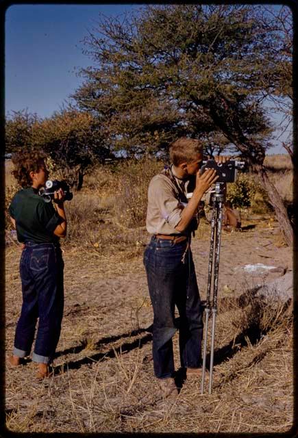 Elizabeth Marshall Thomas holding a camera and John Marshall filming