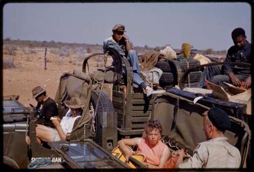 John Marshall and Elizabeth Marshall Thomas resting in expedition GMC truck, Wilhelm Camm, Kernel Ledimo and other expedition members in a truck behind