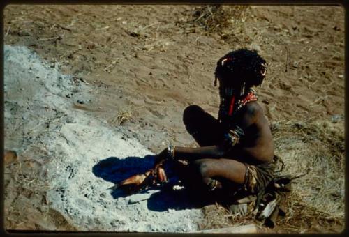 Children, Eating: Girl cooking something in the ashes of a fire