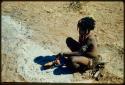 Children, Eating: Girl cooking something in the ashes of a fire