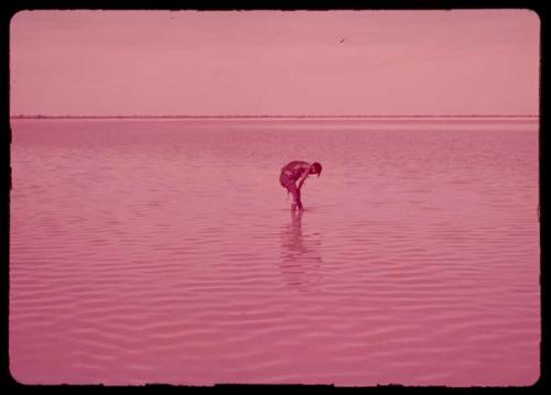 Woman bathing in water-filled pan, distant view