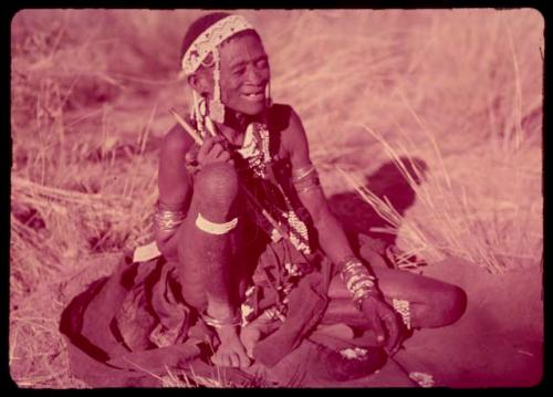 /Gam wearing a headdress of European beads, sitting