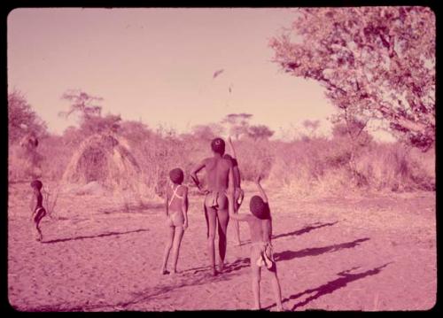 Boys throwing a djani (helicopter toy) into the air