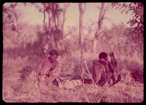 "Gao Medicine" and another man lighting a fire for the night, with their bows and quivers on the ground next to them