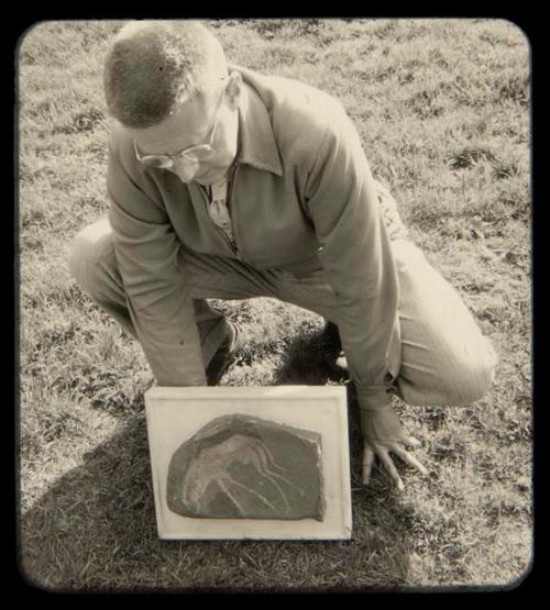 Person holding a petroglyph of a wildebeest (39-95-50/1496)