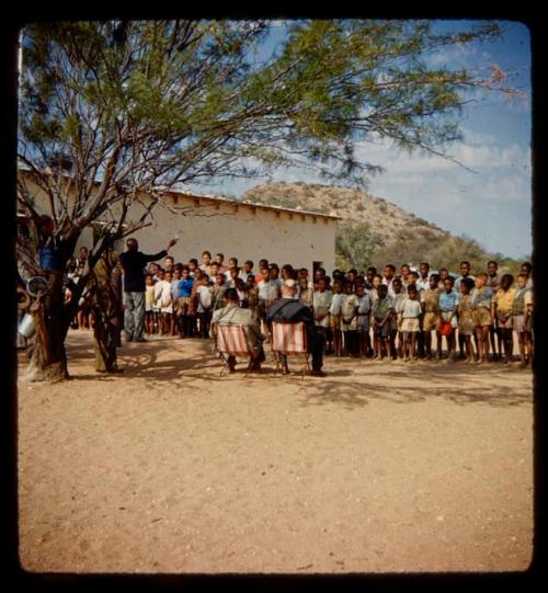 Large group of children at a school being inspected by Colonel Hoogenhout and Mr. Nesser