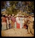 Franzfontein indaba, group of people, mostly women, standing, with Merl La Voy walking in front of them