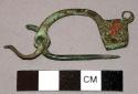 Fibula of bronze, perforated arc axe