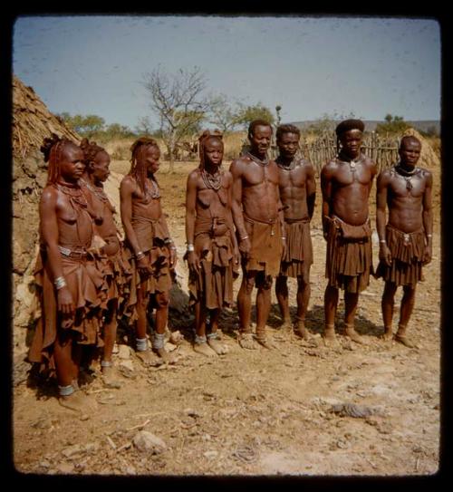 Group of people standing next to a hut