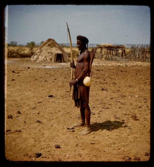 Man standing, carrying bow and arrows, profile