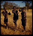 Three people carrying gourds on carrying sticks