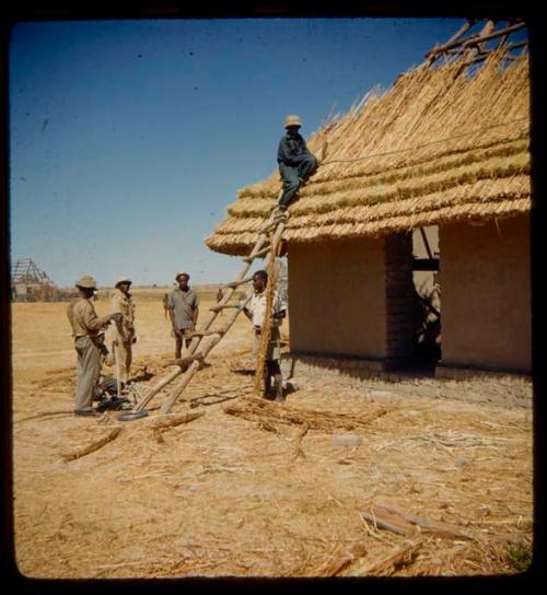 Men thatching a roof at a mission station