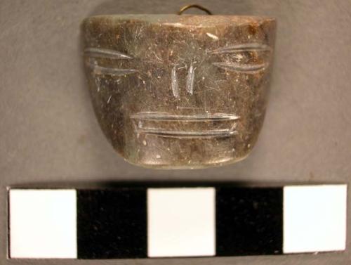 Jade pendant representing a human face, crudely incised