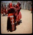 Some of Nehemiah's wives standing, view from behind, with children standing in the background