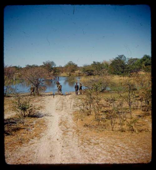 Men standing at a place where the road to Ondongua is under water