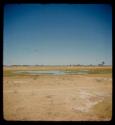 Small pan filled with water, with trees in the distance