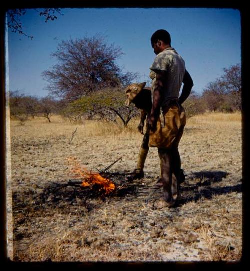 Two men, one a soldier guide, cooking something in a pot on a fire