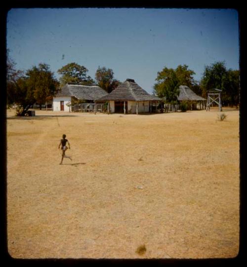 Boy running, with mission buildings in the background