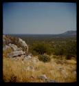 Rocky hillside, with mountains in the distance