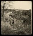 Two expedition members standing, with the Okavango River in the background