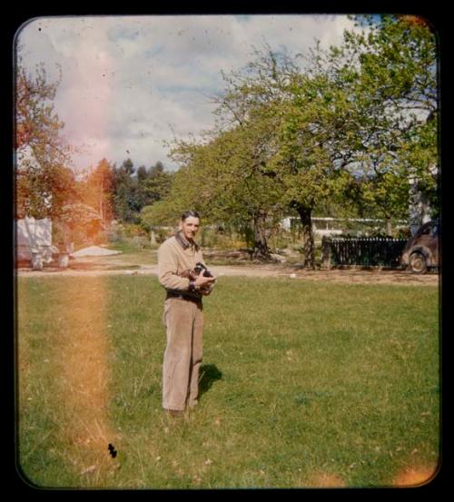 Franz Malan standing on his property, holding a camera