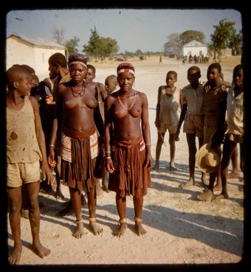 Group of people standing, with buildings in the background