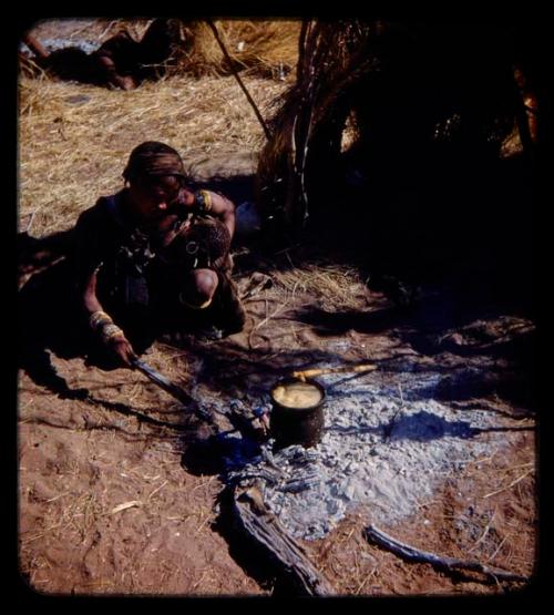 Di!ai ("Gao Medicine's" wife) holding /Gaishay (her son), cooking