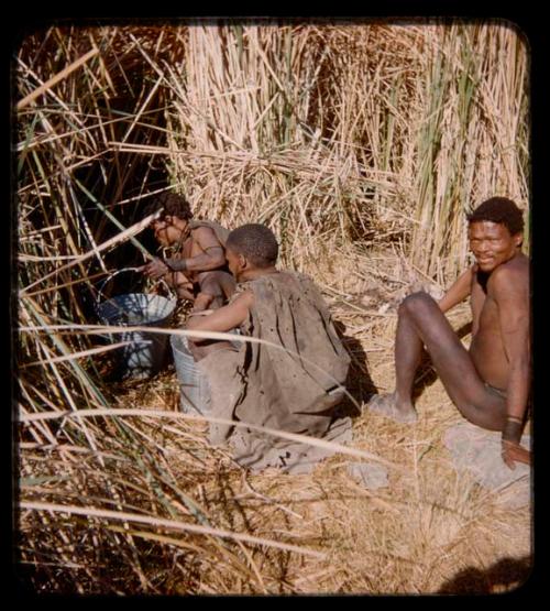 ≠Toma, /Qui and "Gao Medicine" sitting next to a waterhole, with two metal buckets